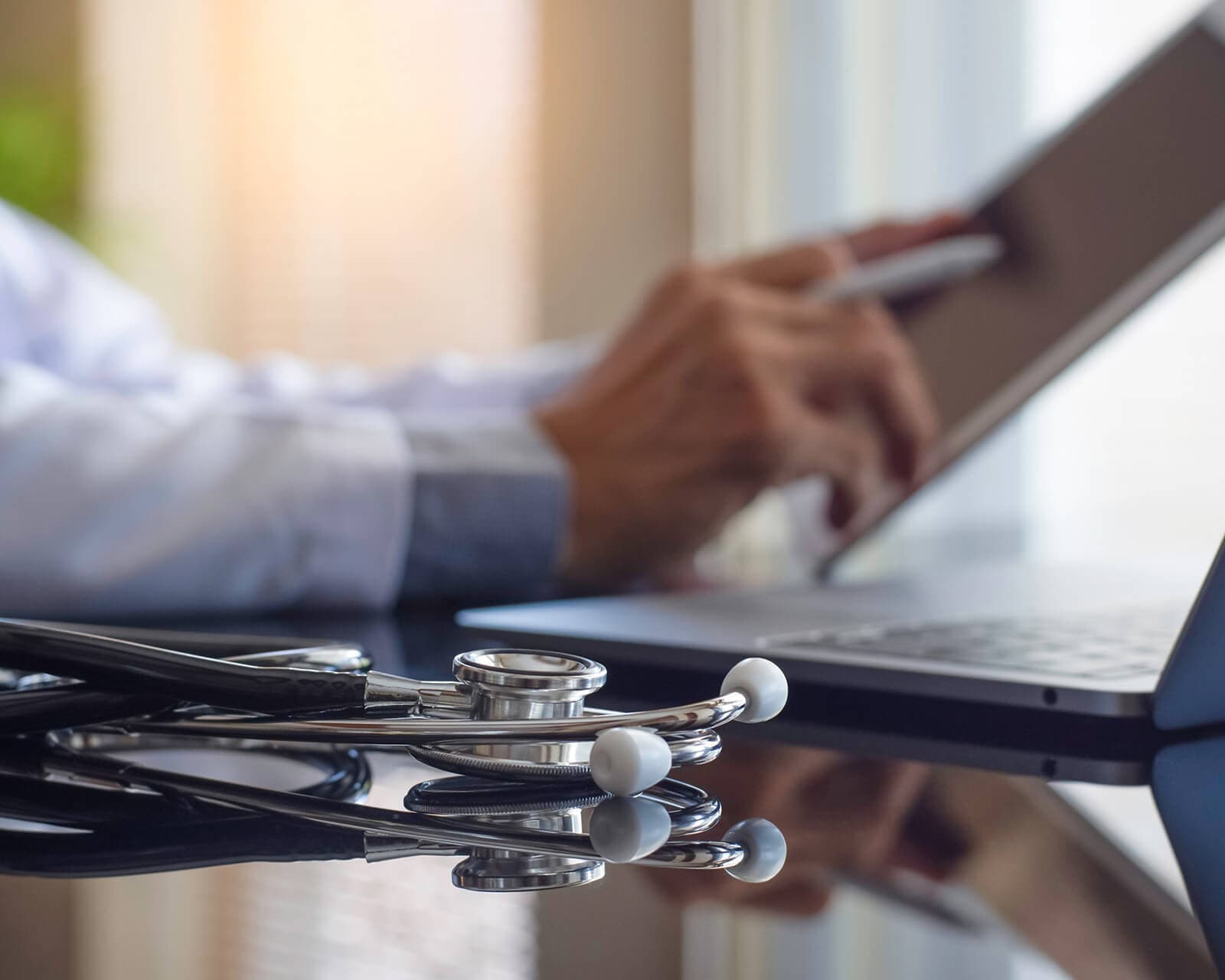 Physician reviewing a patient case on a tablet.